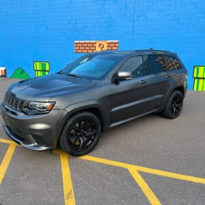 This 2018 Jeep Grand Cherokee Trackhawk is a preowned vehicle with the bright white clear coat exterior and black/sepia suede/nappa performance seats.