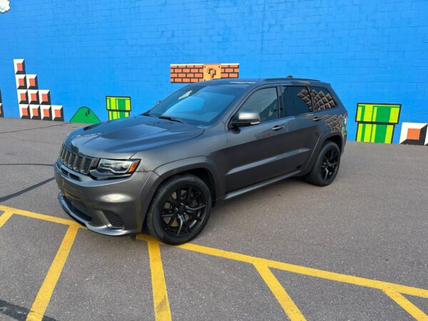 This 2018 Jeep Grand Cherokee Trackhawk is a preowned vehicle with the bright white clear coat exterior and black/sepia suede/nappa performance seats.